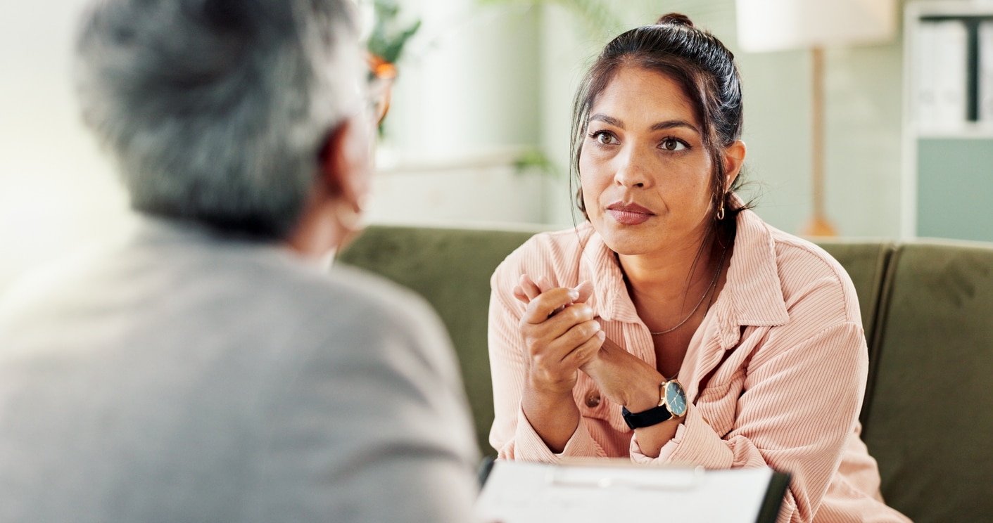 A woman practices present listening with a patient in a clinical environment.